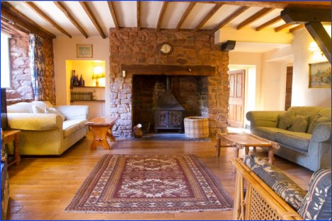 Main sitting room with inglenook & woodburner in The West Wing Cottage